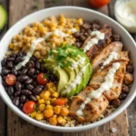 High-protein lunch bowl with grilled chicken, quinoa, black beans, avocado and fresh vegetables - quick healthy meal prep idea